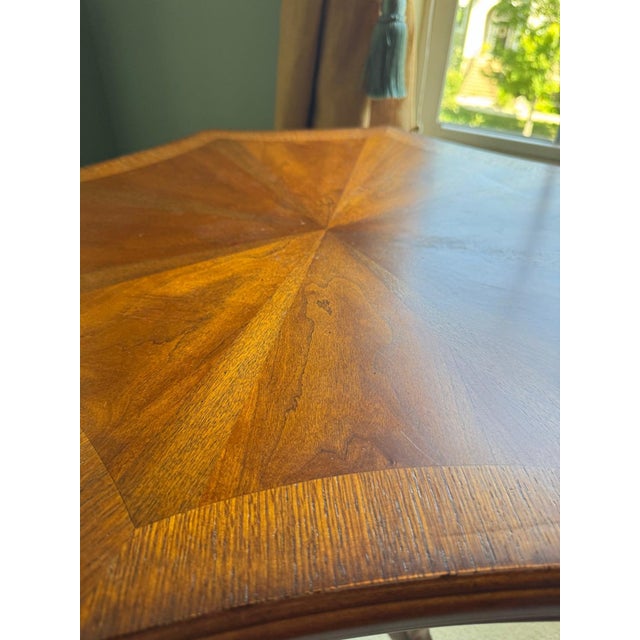 A traditional English Regency-revival accent table: an octagonal scalloped-edge top with a book-matched sunburst veneer...