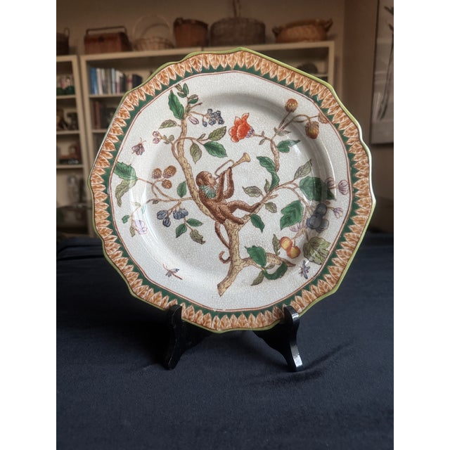 A set of four vintage Chinese export porcelain plates, each hand painted with a different monkey scene set among flowering...