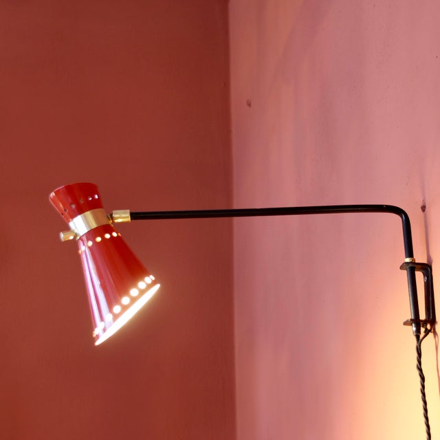 DIABOLO articulated gallows wall light, 1950s. In red painted aluminum, black painted metal and brass Arm length: 43.5 cm...
