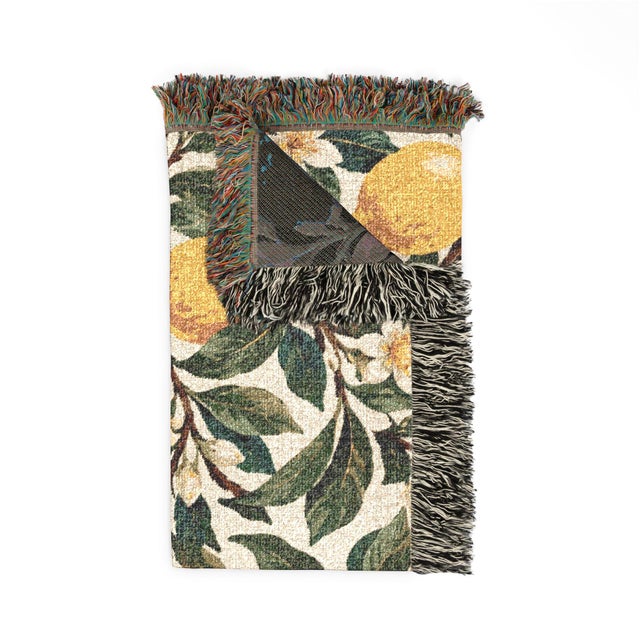 This lemon botanical woven throw blanket features golden yellow lemons, leafy green branches, and ivory blossoms on warm...