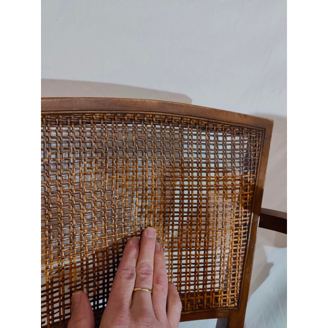 Elegantly designed cherrywood armchair with cane seat and back. Uniquely curved and tapered legs and armrests. Cane...