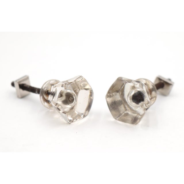 Vintage cabinet or drawer knobs made of clear glass with a hexagon shape and a bullet center. Mounting screws are...