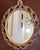 Large ornate Rococo style mirror in a beautiful classic gold finish with the red undertone (called bole) showing under the...