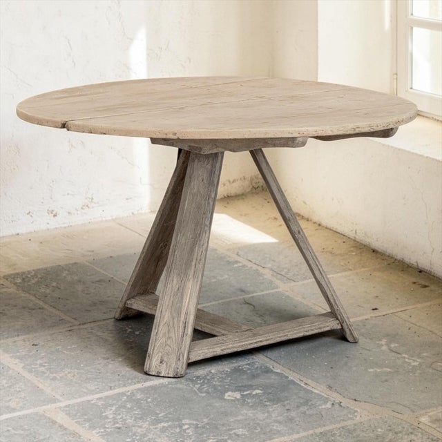 An 18th century Dutch country tilt top table in stripped oak, with a broad round top of wide planks resting on a sturdy...