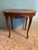A beautifully crafted oval side table in the Louis XV style, featuring graceful cabriole legs, a scalloped and carved...