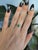 A Colombian emerald in a vivid, slightly bluish green sits at the heart of this solid 14K white gold ring, flanked by two...