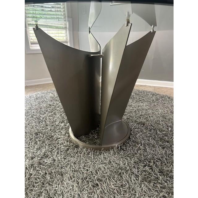 The table features a large (48"), round, clear glass top with beveled edge. From the Italian designer, Cattelan, the base...