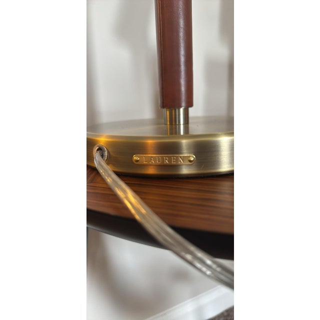 Striking pair of authentic Ralph Lauren Home campaign-style table lamps featuring brushed brass metal shades, brown...