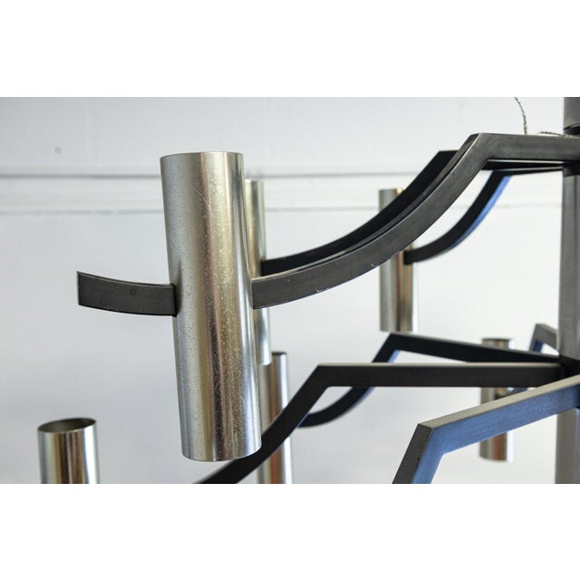 A black and chrome candelabra chandelier ceiling light fixture. This piece features a black metal and chrome finish...