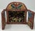 This folk art diorama features a mask store or workshop. The colorful figures and masks are typically crafted from a...