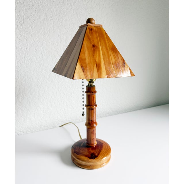 Unique mid-20th-century folk art style table lamp. Handmade base and shade constructed from cedar wood. Features solid...