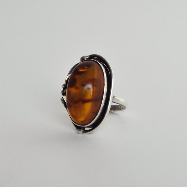 Art Nouveau Amber sterling silver statement ring. The 2.5 x 1.5 cm amber cabochon is set in a sterling silver frame with...