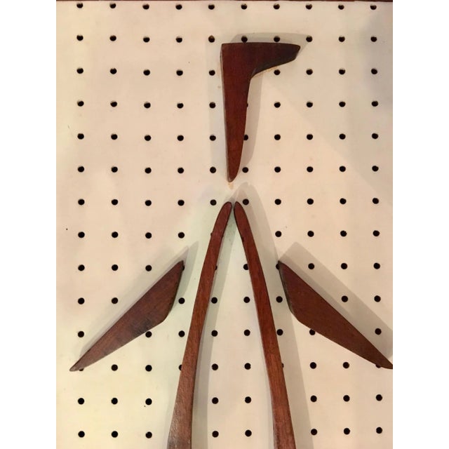 Great sculptural stylized penguins made of solid wood on perforated hardboard. There are two feet that have been reglued....