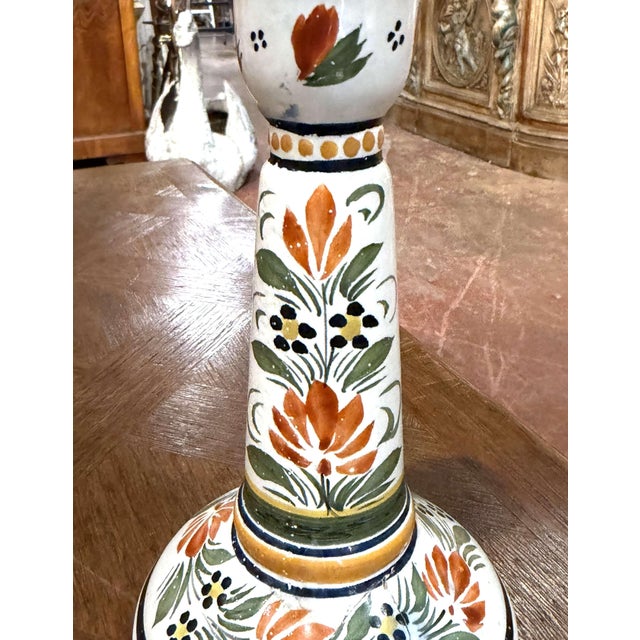 This colorful French faience candlestick is a classic example of Quimper pottery, celebrated for its hand-painted Breton...