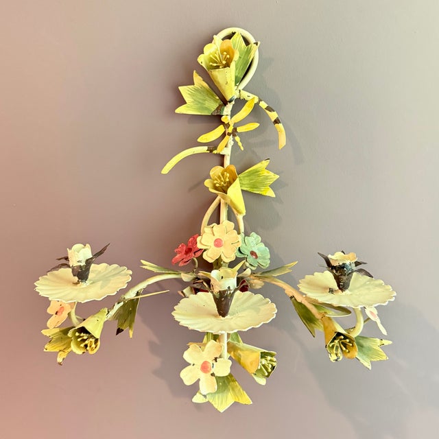 From Italy, a charming pair of Tôle Peinte floral candle wall sconces, made of hand-painted iron, circa mid 1900s. Showing...