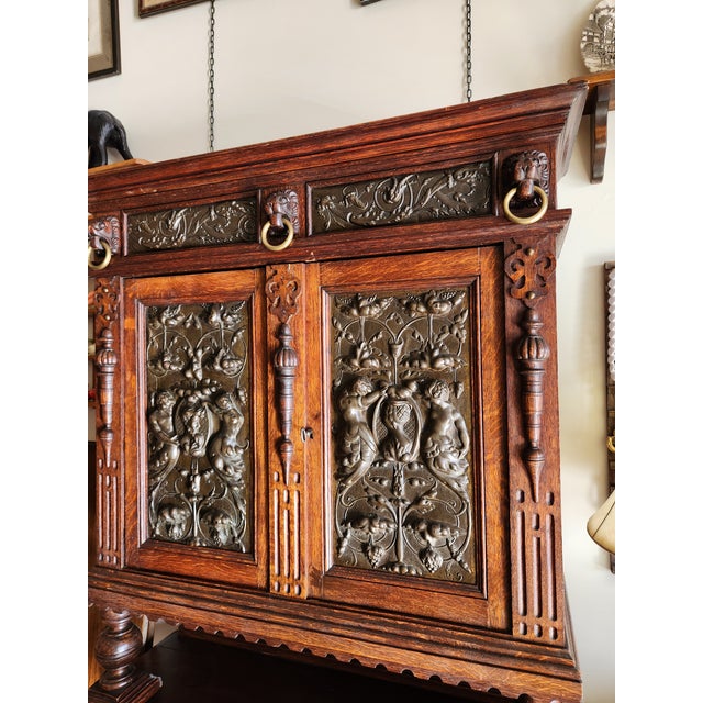 Victorian Jacobean Revival (1870-1910) hutch. The hutch has brass panels with beautiful embossed designs on the doors, the...