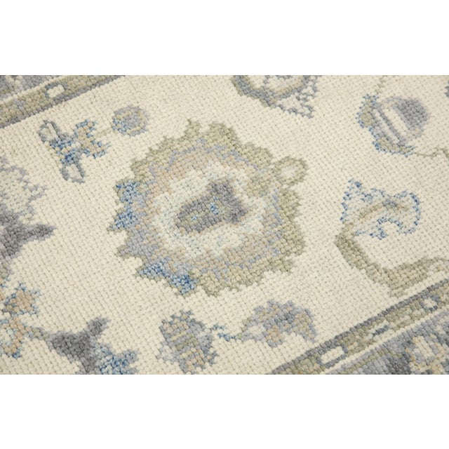 This modern Turkish Oushak rug is a stunning piece of art that has been handwoven using traditional techniques by skilled...