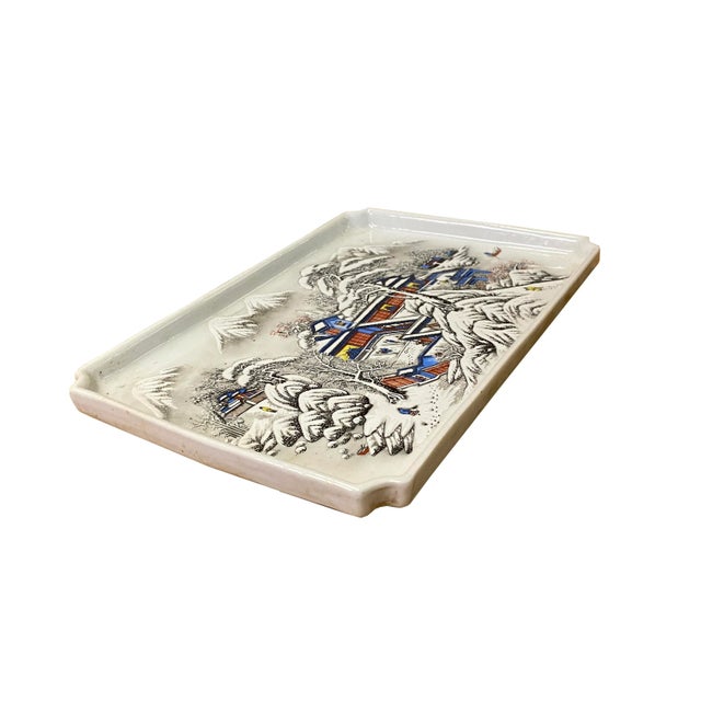 This is an oriental Chinese decorative plate with a distressed off white base and oriental snow tree house scenery...