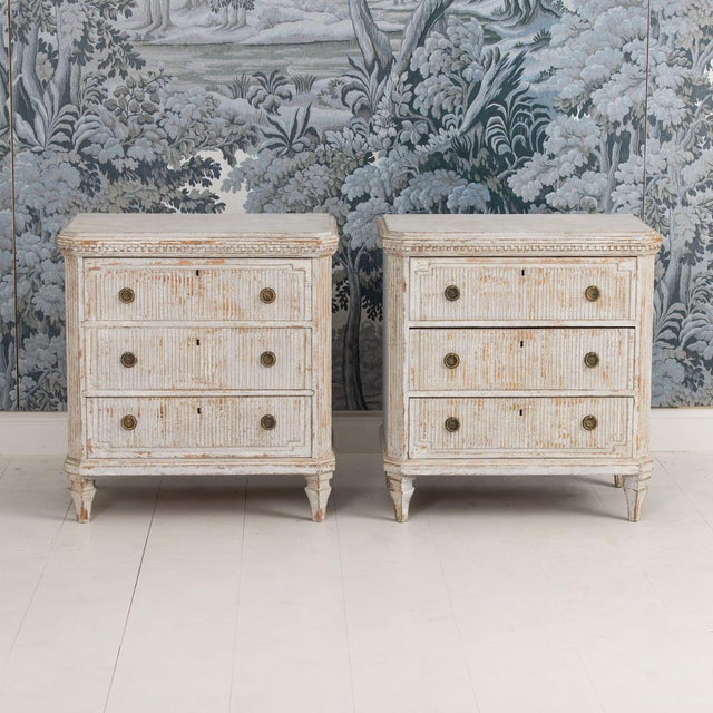 A pair of Swedish Gustavian style commodes in original paint. These chests have beautiful reeded drawer fronts with dentil...
