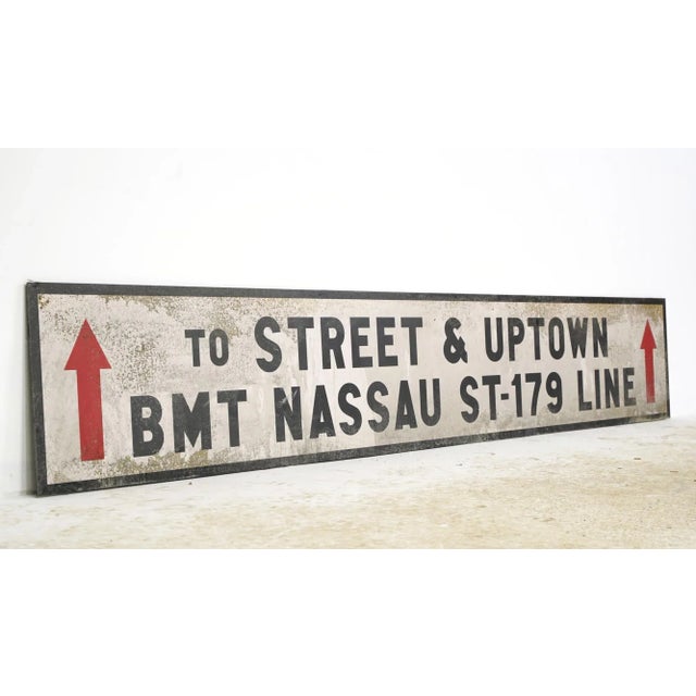 Reclaimed movie set street sign made of plastic foam board in white and black colors with red arrows. The sign reads "To...