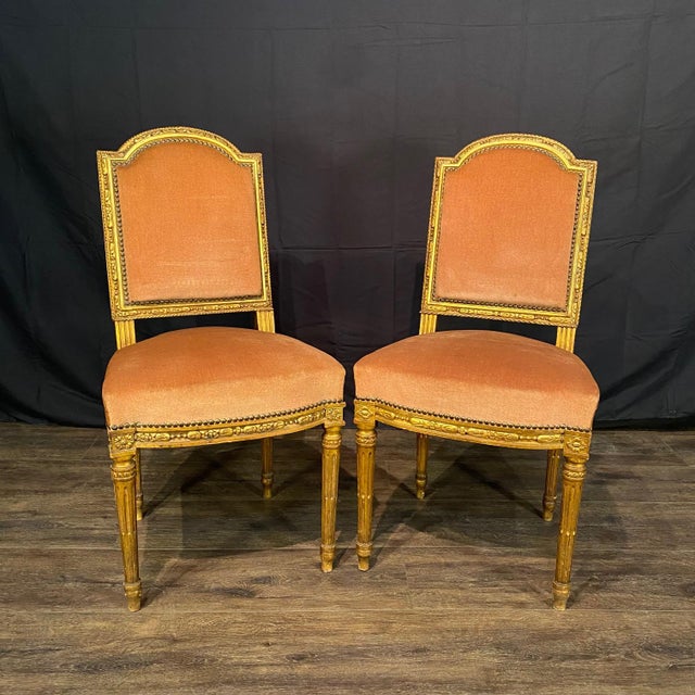 A beautifully matched pair of antique French Louis XVI side chairs from the Napoleon III Belle Epoque era. Crafted with...