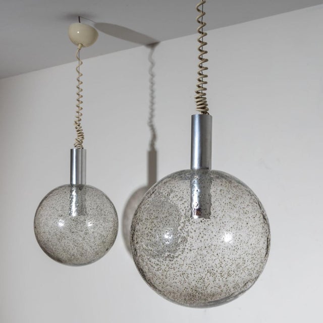 A pair of pendant lamps designed by Tobia Scarpa for Flos in 1964. The globe-shaped bodies are crafted from frosted glass,...