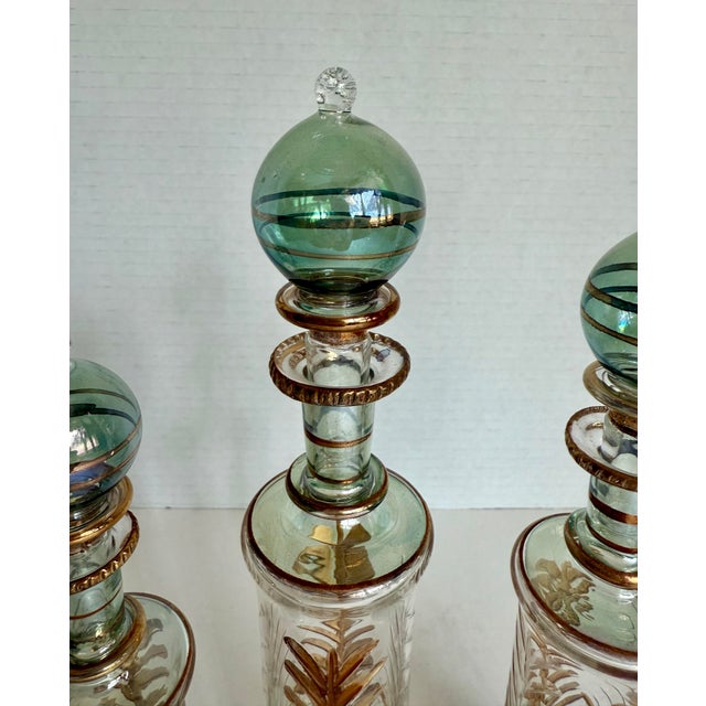 This decorative set of three Egyptian hand-blown glass bottles in varying heights, was likely produced in the later mid-...