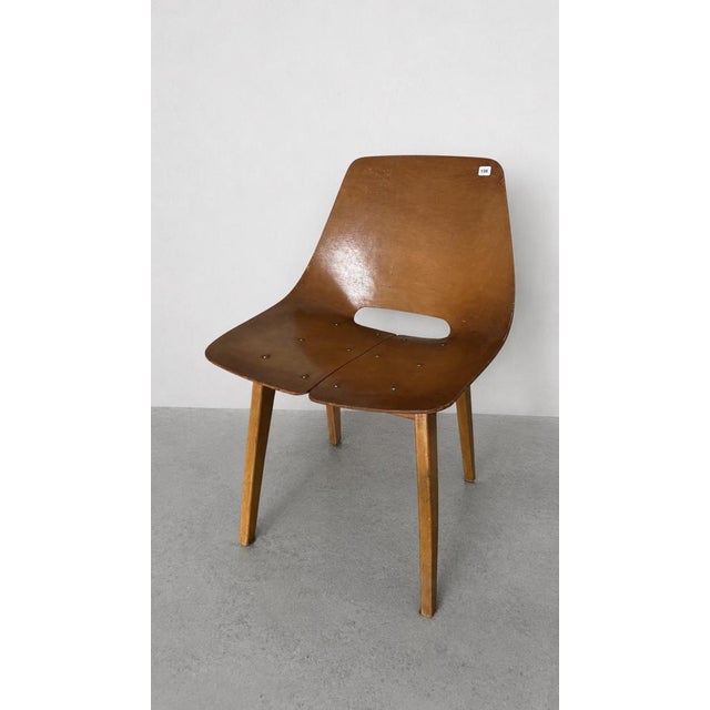 Pierre Guariche 1926-1995 Barrel-shaped chair, 1954. Molded plywood, wooden legs, and removable green seat cushion....