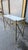 Console table made entirely of brass, supported by X-shaped crosspieces and elegant lion paws. Original marble top nestled...