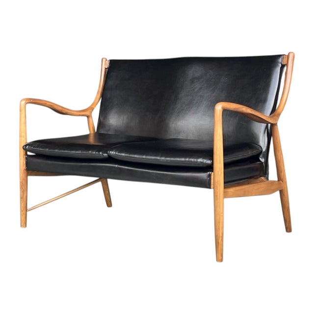 This elegant mid-century modern loveseat showcases refined Danish-inspired craftsmanship with a beautifully sculpted solid...