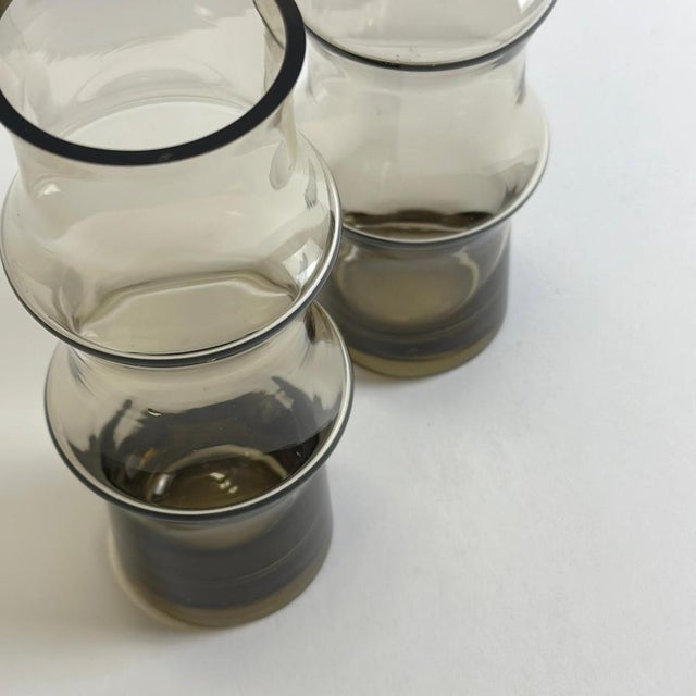 A pair of vintage smoked glass vases, likely produced in Eastern Europe—possibly Romania—circa the 1960s. The vases...