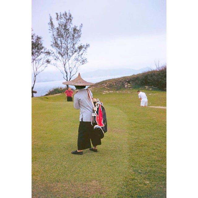 In The Bunker by Toni Frissell A caddy watches a golfer playing a shot, Hong Kong, 1959. (Photo by Toni Frissell) 20x16"...