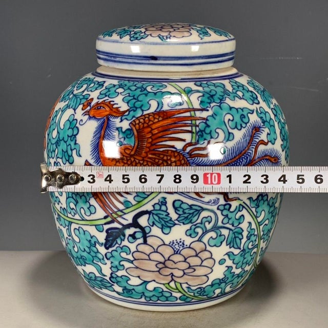 A striking Chinese porcelain covered jar decorated in vibrant Wucai (five-color) enamels. The white ground is vividly...
