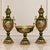 Elegant three-piece French-style porcelain garniture set featuring two matching covered vases and a coordinating central...