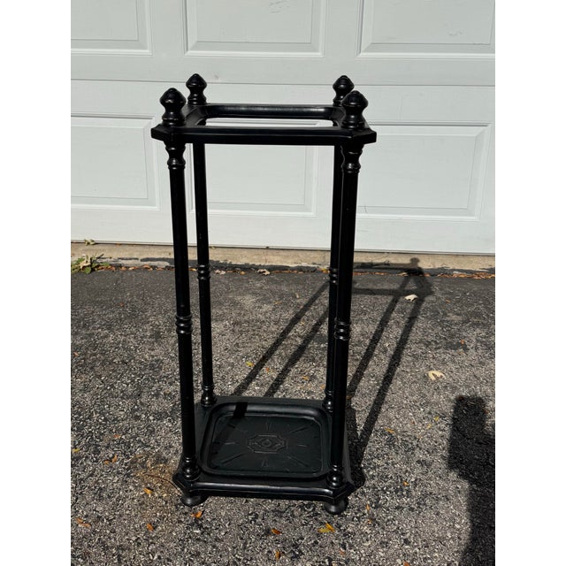 Black Umbrella or Walking Stick Stand With Removable Drip Tray. Has a worn look where the brown wood shows on the edges....