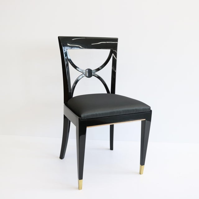 A striking set of four Art Deco dining chairs designed by De Coene Frères. Black lacquer frames with patinated bronze...
