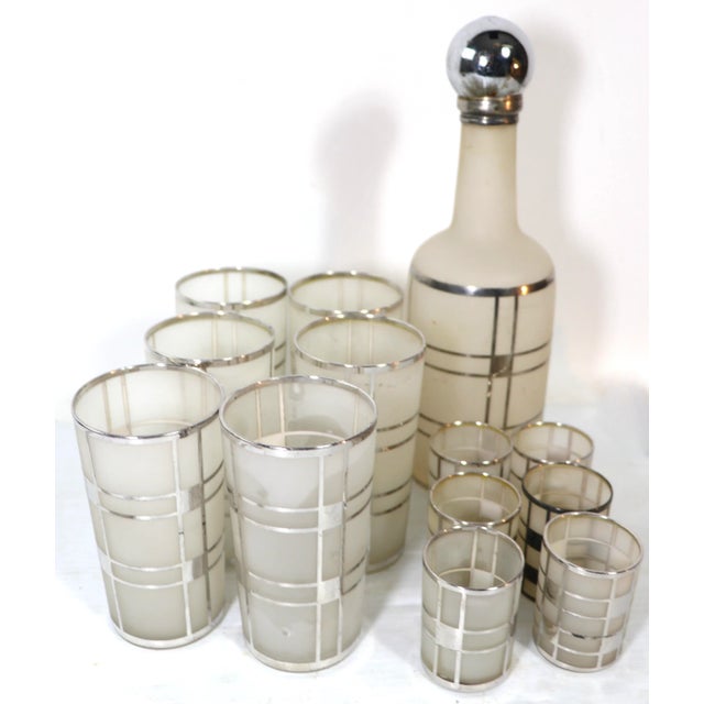 Spectacular silver overlay cocktail set, having a frosted white glass ground with Machine Age geometric silver overlay...