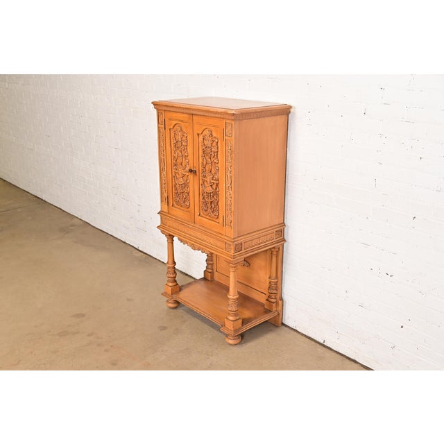 A gorgeous antique Renaissance Revival carved oak bookcase, cupboard, or bar cabinet In the manner of R.J. Horner & Co....