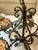 Black wrought-iron chandelier with five arms adorned with additional iron flourishes as well as tole gilt leaves and buds....