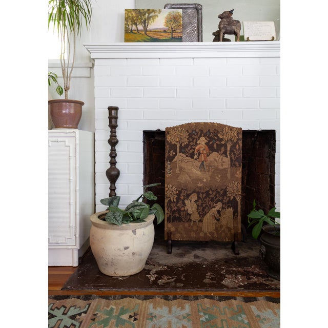 This English Arts and Crafts-style fireplace screen is upholstered in a burlap-like fabric with a tapestry look and...