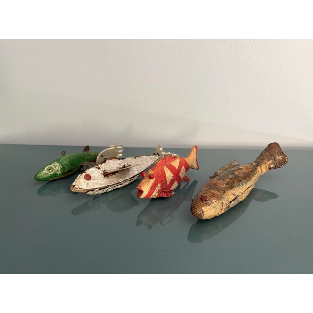 Group of four vintage weighted ice fishing/spear fishing decoys. Each is a hand carved wood fish with polychrome...