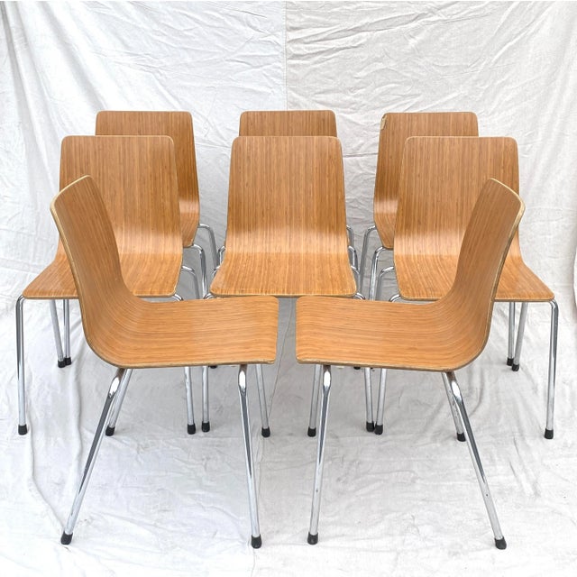 1960s set of eight stacking molded plywood dining chairs with chrome legs. Seats, 16"W x 14"D x 18"H.