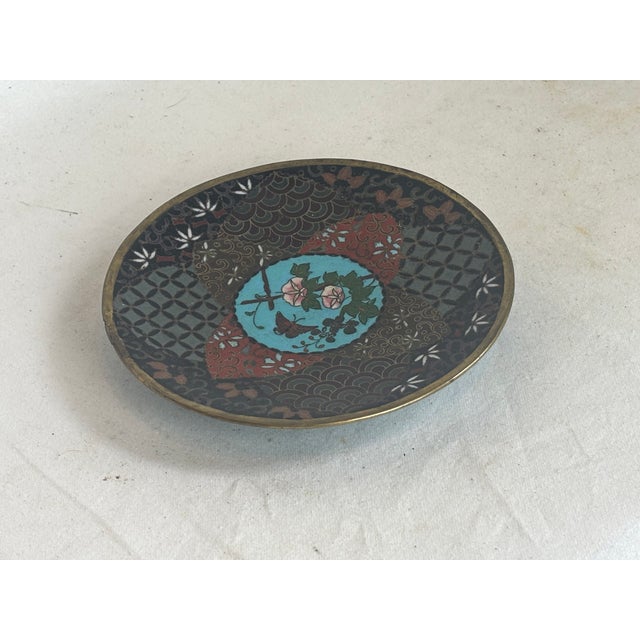 This beautiful dish has designs depicting florals, leaves, geometric shapes, and a butterfly.