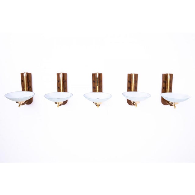 Art Deco wall lamps from around 1950, Poland. The wall lamps have a wooden base with a simple, slightly geometric form...