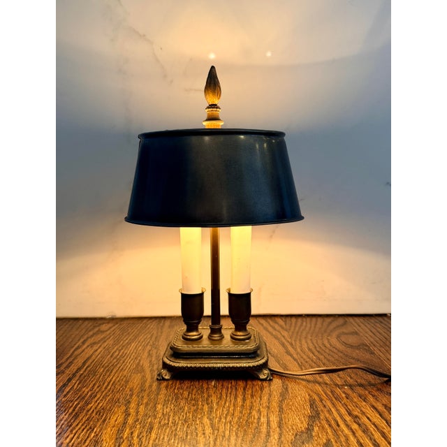 A charming vintage Bouillotte-style desk lamp featuring a classic black tole-style shade, dual faux candle lights,...