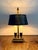 A charming vintage Bouillotte-style desk lamp featuring a classic black tole-style shade, dual faux candle lights,...
