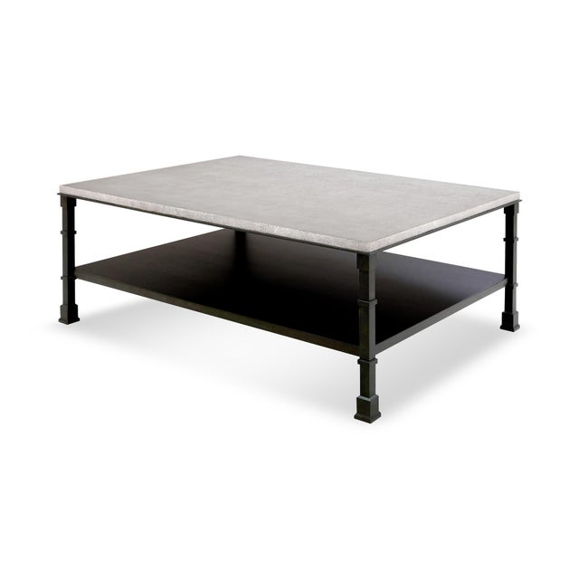 A textured, faux concrete top and a steel frame with a wrought iron finish make this coffee table a great canvas for...