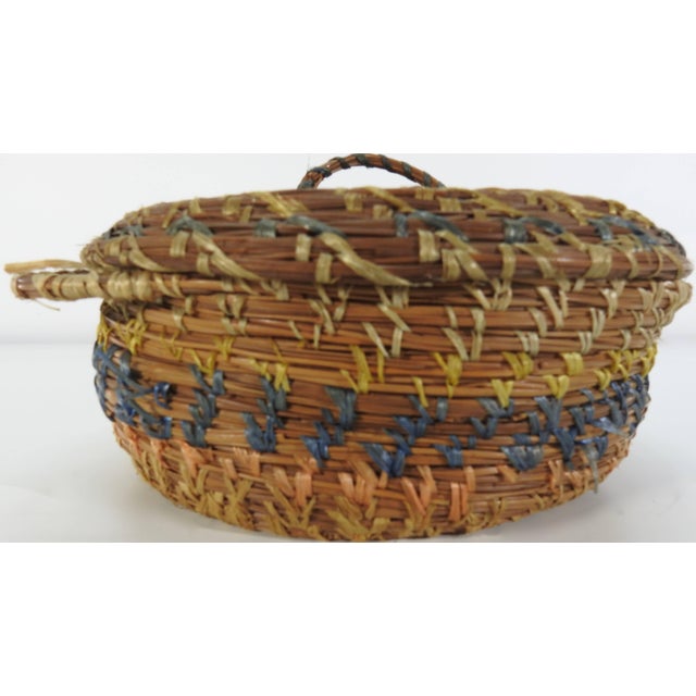 This vintage basket from China in the 1940s is constructed of pine straw and accented with various shades of dyed raffia....