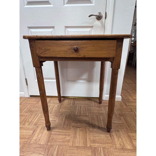 A 19th century country Sheraton side table in pine, with the ring-turned, tapering legs typical of the style. The two-...