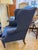 This is an 1800s antique wingback chair. It is newly reupholstered with a beautiful blue linen. The armrests feature a...